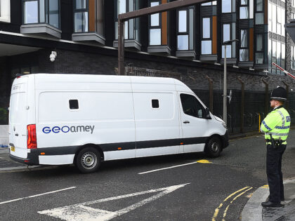 A prison van goes past police officers standing guard outside Liverpool Magistrates'