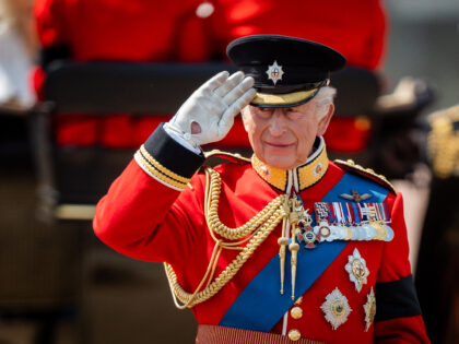 King Charles III gives a salute as he watches the parade march past after arriving back at
